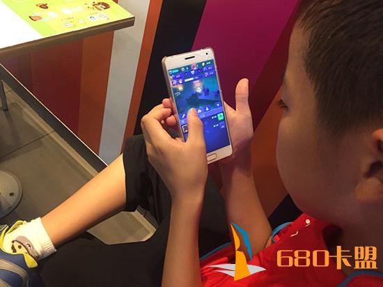 梁昊拿着爸爸的手机，游戏玩得入了迷。